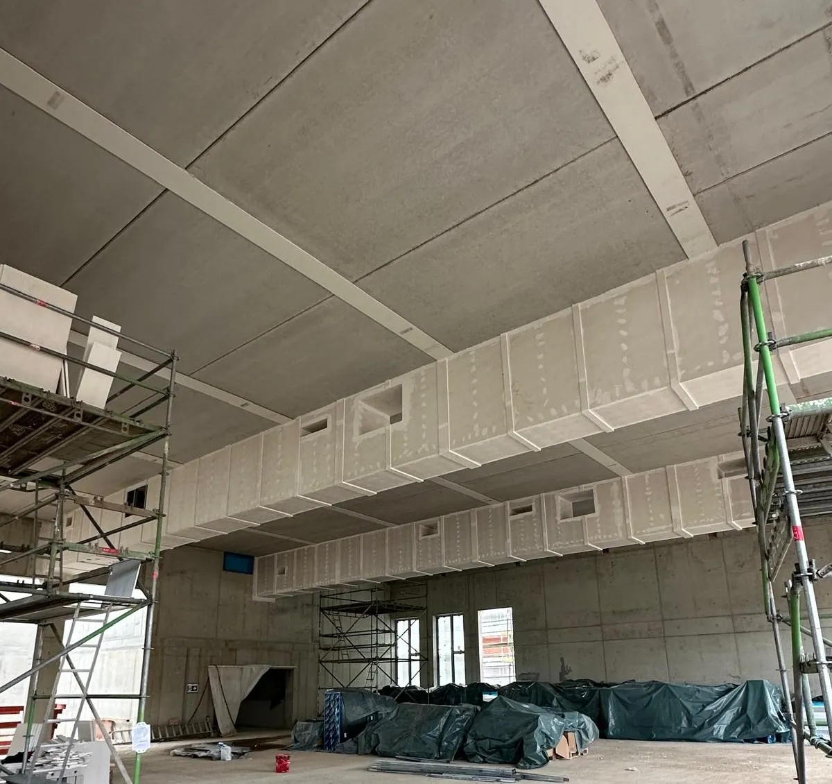 Brandschutzbekleidete Kanaltrasse auf der Baustelle, eingerüstet